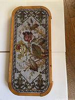 Top view of the tea tray showing the full beadwork floral pattern and wooden frame.