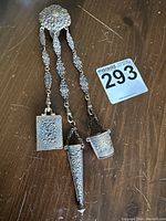 Full view of chatelaine showing ornate clasp, three filigree chains and attached implements