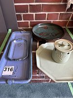 Overall view of assorted pottery including blue rectangular trays, round green bowl, octagon tray and garlic keeper with lid