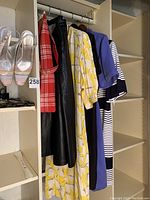 Photo showing hanging clothes including leather skirt, vintage Dior dress, and Jaeger dresses.