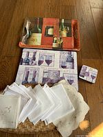 Photo of two rectangular serving trays, assorted cloth napkins in white and cream laid out on a flat wooden surface.