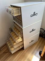 Stack of three white DMC thread storage cabinets with drawers open