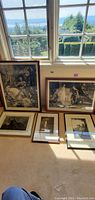 Six framed black-and-white lithographs arranged beneath a window
