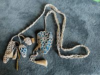 Full view of vintage handmade lace chatelaine with multiple attached needlework items including scissors, pincushion, and tools.
