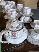 Overall view of tea set arranged on table showing cups, saucers, teapot, creamer and sugar bowl