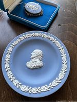 Photo of Wedgwood jasperware dish featuring central classical bust relief and surrounding leaf border on light blue background