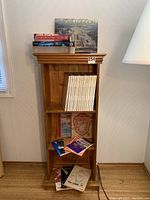 Front view of solid wood bookcase with four shelves holding various books including Smithsonian series