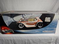 Front side view of the Hot Wheels Beatnik Bandit diecast car in original box