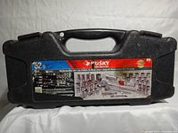 Closed black hard plastic carrying case with label showing Husky branding and 52-piece mechanics socket set details.
