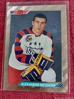 Close-up photo of a Bowman hockey card featuring Alexander Mogilny in white NHL All-Star jersey, holding yellow TPS gloves.