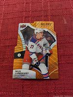 Photo of the Upper Deck Allure Rookie hockey card featuring Nils Lundqvist in Rangers uniform, showing front side of the card with holographic design.