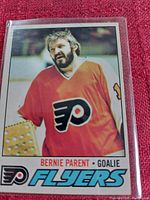Photo of Bernie Parent hockey card in plastic sleeve, showing front with orange Flyers jersey and team logo