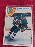 Close-up of Bryan Trottier hockey card featuring him in Islanders uniform skating on ice.