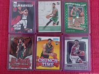 Six Donruss Jayson Tatum basketball cards arranged in two rows of three, each card in a protective plastic sleeve on a red fabric background.