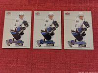 Three Alexander Ovechkin hockey cards from Fleer Ultra laid flat on a red surface, showing front image and branding.