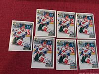 Seven Martin Brodeur Upper Deck Star Rookies hockey cards laid out on red fabric surface, six arranged in two rows of three and one card to the side.