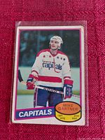 Photo of Mike Gartner hockey card showing front of card with player in Capitals white jersey and helmet, holding stick on ice.