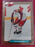 Single hockey trading card featuring Ray Ferraro mid-action on the ice, wearing a white jersey with Canadian hockey team colors and a helmet; card has a pink metallic border with the Bowman logo.