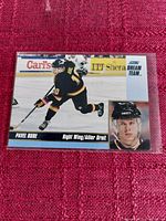 Photo of Score Dream Team Pavel Bure hockey card in protective sleeve on red fabric background.