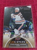 Card image showing Ryan Nugent-Hopkins in Edmonton Oilers uniform mid-play with Upper Deck UD Canvas logo and player details