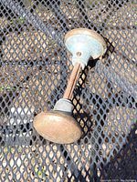 Two connected antique metal door knobs with rust, showing length and condition.