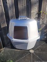 Front view of the light gray covered cat litter box showing a large rectangular entrance and a handle on the top.