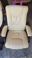 Front view of white leather office chair with padded armrests and seat.