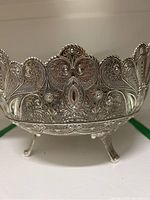 Side view showing filigree pattern and decorative leg
