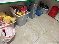 Bins containing stuffed animals and assorted toys on the floor