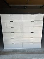 Front view of the chest of drawers showing twelve drawers wrapped in plastic.
