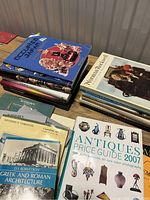 Overhead photo showing stack of reference books on Norman Rockwell, antiques, Sothebys Canadian art, Greek and Roman architecture, and antiques price guide 2007.