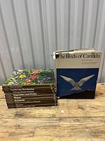 Photo of the Time-Life Encyclopedia of Gardening volumes stacked with their titles showing, next to The Birds of Canada book with visible torn dust jacket.