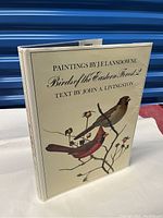 Front cover of dust jacket showing book title and bird illustrations.