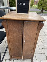 Front view of antique oak pie cupboard with two doors closed, showing wear marks and small metal handle on right door.