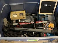 Wide view of all bike accessories and tools packed in a blue plastic storage bin labeled 'LOT 28' on display board