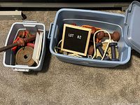 Two bins containing assorted free weights and jump ropes, showing variety in sizes and coating materials.