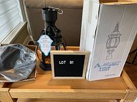 Photo showing the Artcraft outdoor lantern, original box, and packaging materials on a wooden table.