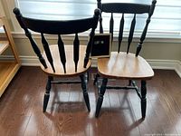 Four vintage pine spindle back chairs with natural seats and dark green painted tops and legs showing wear