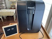 Front view of the black Fellowes shredder showing the power button and branding.