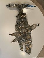 Top view of tin shark sculpture with textured hammered pattern and oxidized patina