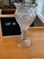 Front view of vintage cut glass footed vase showing starburst and fan pattern and octagonal footed base