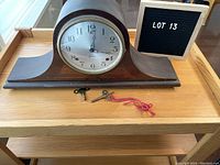 Vintage Sessions Dulciana mantle clock with curved wooden mahogany base and two winding keys placed in front.