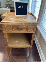 Front view of vintage wooden night stand showing drawer with metal pull, vertical grooved detailing, and worn surface needing refinishing.