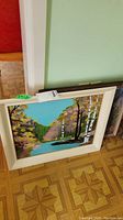 Framed original painting showing a lake with birch trees, colorful autumn foliage, and blue sky.