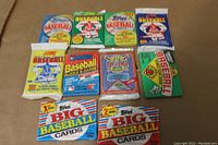 Ten unopened baseball card packs from different brands and years shown in colorful wax, cello and foil packaging.
