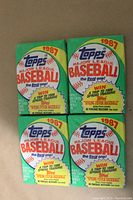 Photo of front of four 1987 Topps Major League Baseball wax packs, unopened, green and yellow color, text and logo visible