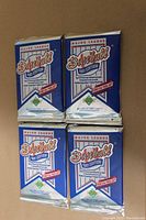 Top view of four sealed 1991 Upper Deck Major League Baseball foil packs arranged in a 2x2 grid, showing front of packs with logos and labeling.