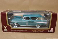Front view of factory-sealed 1/18 scale diecast 1957 Chevrolet Nomad model in original box showing blue and white vehicle.