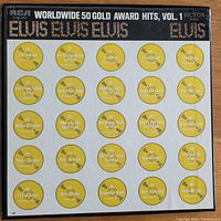 Photo of the album cover showing the RCA Worldwide 50 Gold Award Hits, Vol. 1 with yellow record labels graphic and track title list, highlighting Elvis Presley hits from 1956 to 1970.