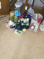 Full lot overview showing various cleaning supplies, storage bins, an enamel bucket, gloves, and a green cup.